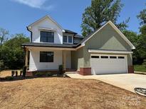 Charming two-story home with white and green siding, a two-car garage, and a well-manicured front yard at 1906 Maius Dr, Conover, NC 28613