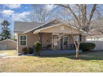 Charming bungalow featuring a covered porch with decorative ironwork and a well-maintained front yard at 205 S Pine St, Dallas, NC 28034