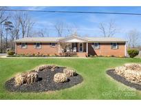 Charming brick home featuring a well-maintained lawn and landscaping with a welcoming covered entryway at 2417 Fowler Secrest Rd, Monroe, NC 28110
