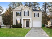 Charming two-story home featuring a manicured lawn, attached garage, and classic architectural details at 2868 Oasis Ln, Charlotte, NC 28214