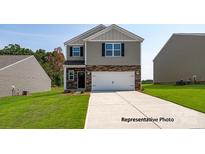 Charming two-story home featuring stone accents, a two-car garage, and a well-manicured lawn at 1032 Hostler Ln, York, SC 29745