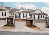 Charming townhome featuring a stone facade, attached garage, and landscaped front yard at 1915 Colony Line Ct, Charlotte, NC 28210