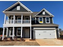 Charming two-story home features a welcoming porch, two-car garage, and a classic dark gray and white color scheme at 2228 Tabor Rd # 569, Sherrills Ford, NC 28673