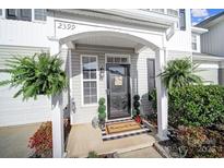 Charming front door with inviting 'Home Sweet Home' doormat and decorative plants at 2399 Woodridge Dr, Fort Mill, SC 29715