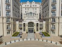 A beautiful, symmetrical exterior view of an elegant condo building with landscaped entrance and black iron accents at 2823 Providence Rd # 236, Charlotte, NC 28211