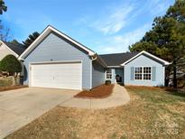 Charming single-story home with attached garage, manicured lawn, and light blue siding at 3212 Irwin Valley Ct, Charlotte, NC 28269