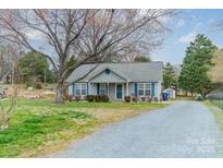 Charming single-story home featuring blue shutters and a well-maintained lawn and gravel driveway at 3414 Clearview Dr, Monroe, NC 28110