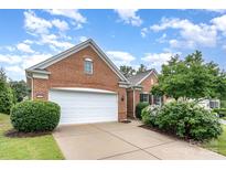 Charming brick home featuring a two-car garage, well-maintained landscaping, and blue sky at 14309 Stonewater Ct, Fort Mill, SC 29707