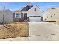 Charming two-story home with well-maintained landscaping and a spacious driveway on a sunny day at 15633 Aviary Orchard Way, Charlotte, NC 28278