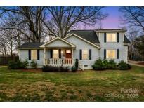 Charming two-story home featuring a cozy front porch and a well-maintained lawn at 1611 Old Hickory Grove Rd, Mount Holly, NC 28120