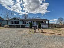 Charming single-story home with light blue siding, front porch, and gravel driveway at 170 Louise Dr, Mooresville, NC 28115