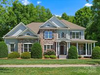 Charming two-story home featuring stone accents, a welcoming porch, and manicured landscaping at 1708 Meadow Crest Ct, Matthews, NC 28104