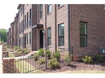 Charming brick townhomes with iron fences and professionally landscaped yards at 210 Gilead Rd, Huntersville, NC 28078