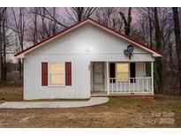 Charming one-story home featuring white siding, red roof, and a cozy front porch at 2407 Moose Rd, Kannapolis, NC 28083