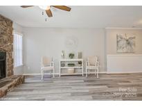 Bright living room featuring stone fireplace, stylish decor, and modern gray flooring at 6212 Windsor Gate Ln, Charlotte, NC 28215