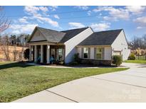 Charming single-story home featuring a well-manicured lawn and covered front porch at 7034 Pin Oaks Dr, Denver, NC 28037