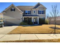 Charming two-story home with well-manicured lawn, inviting porch, and a two-car garage, perfect for families at 858 Oak Manor Se Dr, Concord, NC 28025