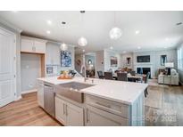 Bright, open kitchen with stainless steel appliances and white countertops overlooks living area at 9930 Cask Way, Huntersville, NC 28078