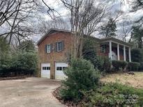 Charming brick home featuring a two-car garage and inviting front porch at 10315 Providence Church Ln, Charlotte, NC 28277