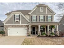 Charming two-story home showcasing a blend of stone and shingle siding and a welcoming front porch at 1048 Harbor Bay Dr, Indian Land, SC 29707