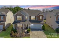 Beautiful two-story home with stone accents, manicured lawn, and a two-car garage at 1100 Wallace Lake Rd, Fort Mill, SC 29707