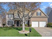 Traditional two-story home featuring a two-car garage, front lawn, and neutral-tone facade at 114 Runningdeer Dr, Mooresville, NC 28117