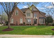 Beautiful brick home featuring well-manicured lawn and complementary landscaping at 18334 Dembridge Dr, Davidson, NC 28036