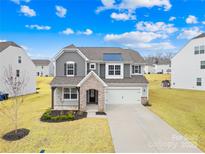 Charming two-story home features stone accents, a two-car garage, and a well-manicured lawn at 367 Kennerly Center Dr, Mooresville, NC 28115