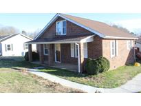 Charming brick home featuring a covered front porch and manicured shrubbery at 410 Cole Campbell Rd, Taylorsville, NC 28681