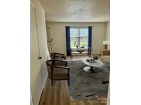 Bright living room featuring hardwood floors, modern furniture, and natural light from the large window at 4520 Central Ave # C, Charlotte, NC 28205