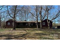 Traditional home featuring a brick foundation, covered porch, and mature trees in the expansive yard at 4926 Stack Rd, Monroe, NC 28112