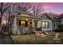 Charming home with a front porch, brick accents, and a well-manicured lawn under a beautiful dusk sky at 524 W Horah St, Salisbury, NC 28144