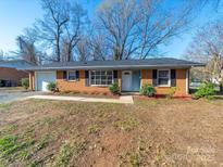 Charming brick ranch home with a manicured lawn and attached garage at 5600 Burleson Dr, Charlotte, NC 28215