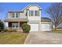 Two-story home with a two-car garage, stone accents, and a well-maintained lawn, perfect for suburban living at 616 Smokehouse Ln, Albemarle, NC 28001