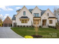 Beautiful brick home with black trim, a manicured lawn, and a concrete driveway at 810 Martingale Ln, Davidson, NC 28036