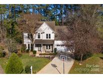 Charming two-story home with a manicured lawn, mature trees, and a basketball hoop in the driveway at 9131 Strattonville Ct, Huntersville, NC 28078