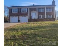 Charming two-story brick home with a well-maintained lawn and a two-car garage, perfect for a Gathering at 1033 College Ave, Shelby, NC 28152