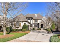 Stunning exterior elevation showcasing a well-manicured lawn and a charming stone and stucco facade at 1355 Wyndmere Hills Ln, Matthews, NC 28105