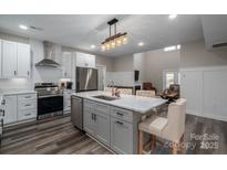 Well-lit, modern kitchen with stainless steel appliances, white cabinets, and a marble island at 150 Shields Dr, Lincolnton, NC 28092