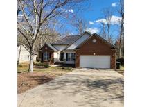 Inviting single-story brick home featuring a well-maintained front yard and an attached two-car garage at 1640 Winthrop Ln, Monroe, NC 28110