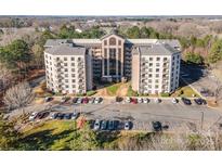 Attractive multi-story apartment building with balconies and plenty of parking in a wooded area at 211 Heritage Blvd # 612, Fort Mill, SC 29715