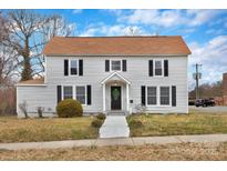 Charming two-story home with light gray siding, black shutters, and a well-maintained front yard at 315 E Washington Ave, Bessemer City, NC 28016