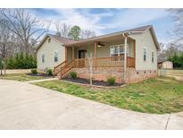 Charming home featuring a cozy porch, wooden railing, and manicured landscaping at 3155 Ramseur St, Lincolnton, NC 28092