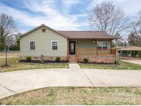 Charming single-story home with a welcoming front porch and well-maintained landscaping and a metal carport on the right at 3155 Ramseur St, Lincolnton, NC 28092