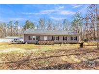 Charming single story home featuring black shutters, a covered deck, and spacious front yard at 330 Chinquapin Ln, Mt Ulla, NC 28125