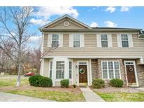 Charming townhome featuring stone accents, neutral siding and a welcoming front entrance with a wreath at 405 Goldstaff Ln, Charlotte, NC 28273