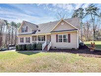 Lovely home showcasing a welcoming front porch, neat shrubs, and green lawn at 5369 Concord Rd, York, SC 29745