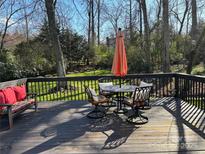 Outdoor back deck features an umbrella-covered table and bench seating, perfect for outdoor entertaining at 7305 Park Vista Cir, Charlotte, NC 28226