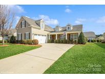 Charming home with a manicured lawn, stone accents, and a welcoming front porch, perfect for enjoying the outdoors at 8633 Sequoia Grove Ln, Charlotte, NC 28214