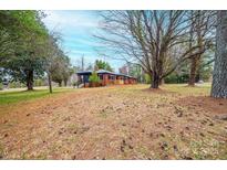 Quaint single-story home with a cozy porch and surrounded by mature trees and a spacious yard at 9026 Nc 10 Hwy, Vale, NC 28168